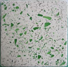 a green and white tile with small pieces of glass on it