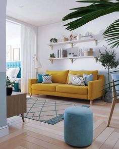 a living room with yellow couches and blue accents on the walls, wooden flooring