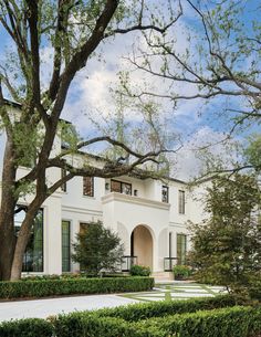 a large white house surrounded by trees and bushes