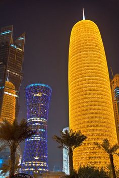 some very tall buildings in the city at night