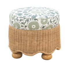 a wicker foot stool with a blue and white flower print cushion on top of it