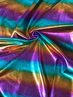 a close up view of a shiny fabric with purple and blue stripes on it's surface