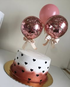 a cake with two balloons on top of it