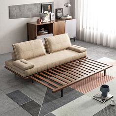 a living room with a couch, coffee table and rugs on the floor in front of a window