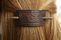 a close up of a hair clip with flowers on it's back and long blonde hair in the background