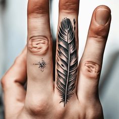 a person's hand with a tattoo on it and a feather in the middle