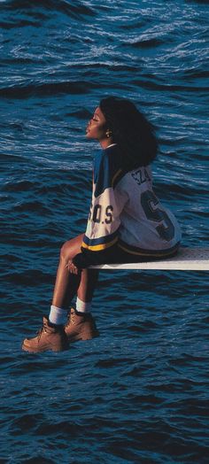 a woman sitting on top of a surfboard in the ocean