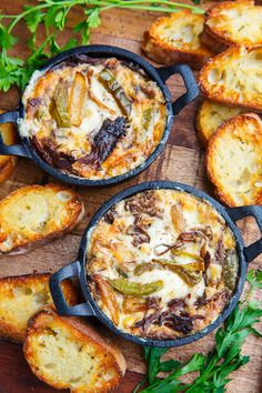 three cast iron pans filled with different types of food and garnished with parsley