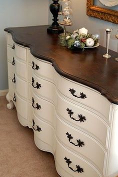 a white dresser with black handles and drawers