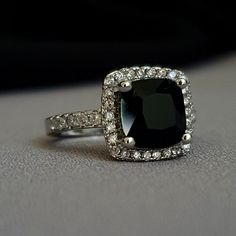 a black and white diamond ring sitting on top of a table