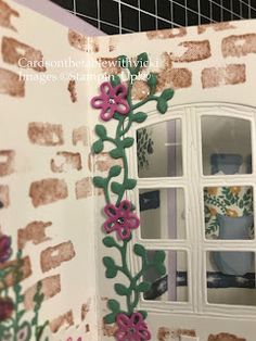 an image of a window with flowers painted on the outside and in the inside wall