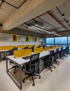 an empty office with yellow and black desks