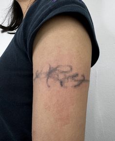 a woman with a tattoo on her arm that has the word love spelled in cursive writing