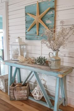 a wooden table topped with a starfish next to a vase filled with sea shells