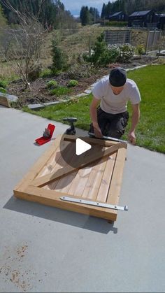 a man working on an outdoor table made out of wood