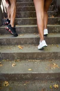 two people are walking up some stairs with their feet on each other's backs