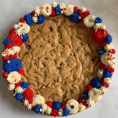 a cookie cake decorated with red, white and blue flowers