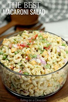 macaroni salad in a glass bowl on top of a wooden cutting board with the title overlay