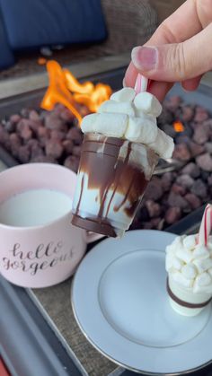 someone is dipping marshmallows into a hot chocolate drink