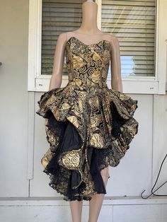 Step out in style with this stunning vintage 80s Studibaker Hawk party dress. The sleeveless black pattterned ball gown features a gold screen print design, adding a touch of glamour to your look. Made from polyester, the original and authentic dress is perfect for a party or special occasion. This XS size dress embodies the 1980s glam rock fashion and is sure to turn heads wherever you go. Don't miss out on this unique and timeless piece. Condition is very very good Preowned condition with no i Vintage Gold Evening Dress For Gala, Vintage Overbust Dress For Party, Vintage Black Sleeveless Evening Dress, Vintage Ball Gown Evening Dress For Costume Party, Vintage Dresses For Gala, Vintage Dresses For Gala And Party Season, Vintage Ball Gown For Costume Party, Vintage Dresses For Gala Party Season, Vintage Gala Dresses For Party Season