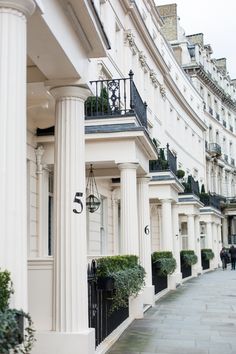 a row of white buildings with black balconies