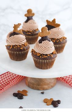 cupcakes with frosting and reindeer antlers on top are sitting on a cake stand