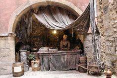 an old stone building with some items on display in the doorway and covered by drapes