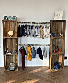 a wooden shelf filled with lots of clothes on top of a hard wood floor next to a white wall