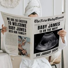 a woman reading a news paper while wearing a towel on her head and holding up a baby james newspaper