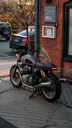 a motorcycle is parked on the side of the road in front of a brick building