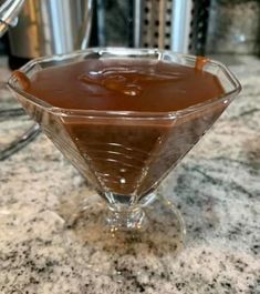 a chocolate sauce in a glass bowl on a counter