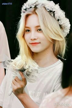 a girl with long blonde hair wearing a flowered headband and holding a knife