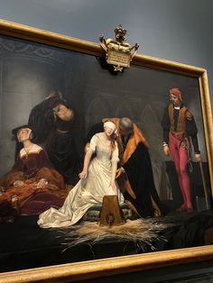 a painting on display in a museum with people standing around