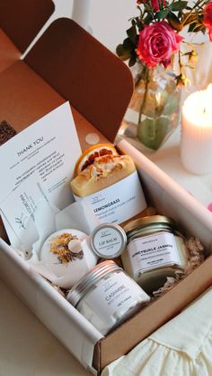 an open box containing candles, soaps and other personal care items on a table