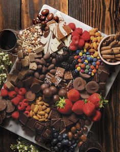 a table topped with lots of different types of chocolates and fruit on top of it