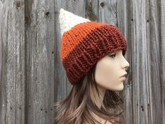 "Knit Hat Style: Gnome Hat - a chunky pointed elf or gnome beanie for women, men and teens. Color: This sample hat is shown in cream, pumpkin orange and spice burnt orange. Sizes: One size fits average teen or adult head size of 20\" to 23\" (50.5 cm to 58 cm). Fiber Content: 80% acrylic, 20% Wool Characteristics: Chunky, very soft, warm and cozy. Care Instructions: Hand wash, dry flat. Every item from Pixiebell is handmade and knit or crocheted to order, unless otherwise stated in title of the Halloween Hat, Gnome Hat, Chunky Knit Hat, Mens Hat, Pixie Hat, Handmade Knitwear, Womens Hat, Halloween Hats, Winter Hats For Men