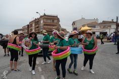 several women in green shirts and hats holding large floats