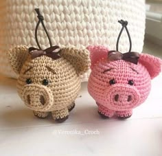 two small crocheted pig keychains sitting next to each other