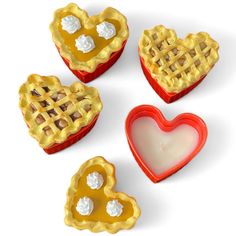 four heart shaped pies are shown on a white background