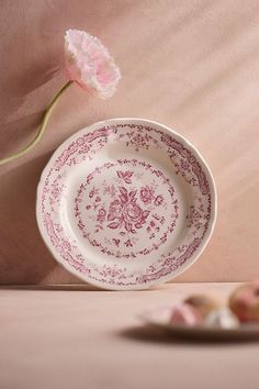 a pink flower sitting on top of a white plate