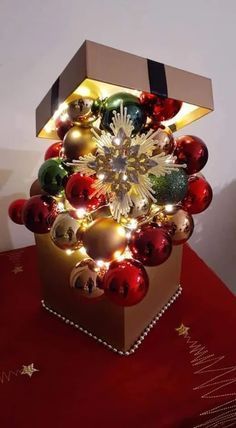 a christmas tree made out of boxes with lights and ornaments on it's sides