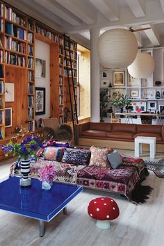 a living room filled with lots of furniture and bookshelves