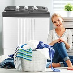 a woman sitting on the floor next to a washing machine