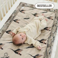 a baby laying on top of a blanket in a crib