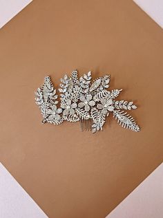 Our GAMILA is the Most Gorgeous and Brilliant Swarovski Bridal Hair Comb that comes with Luxurious Swarovski Crystals and Micro Cubic Zirconia. GAMILA Wedding Hair Comb has a 3D affect with beautifully arranged flowers and leaves. It can be styled on one side, on the back of the hair style or as Wings on both of the sides. The best way to secure it: it already comes with an attached comb to the headpiece and for extra security bobby pins can be used on any part of the headpiece including the loo Arranged Flowers, Bridal Hair Combs, Hair Wings, Boutique Couture, Wedding Hair Pins, Hair Comb Wedding, Free Earrings, Hair Combs, Headpiece Wedding