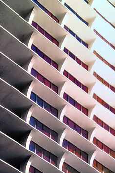 the side of a tall building with windows and balconies on it's sides