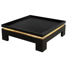 a black coffee table with gold trimmings on the edges and bottom, against a white background