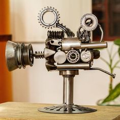 a small metal machine sitting on top of a wooden table