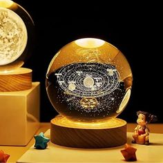 a glass ball with an image of the solar system in it on top of a wooden stand