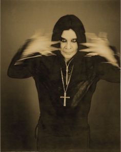 an old photo of a woman with her hands in front of her face and arms outstretched